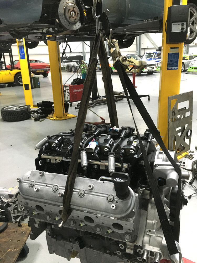 v8 engine on hoist ready to go into vehicle at topcats racing workshop