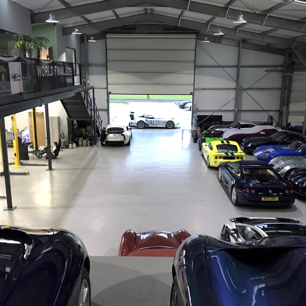 overview of topcats racing large workshop featuring numerous performance and road cars housed in workshop storage facility