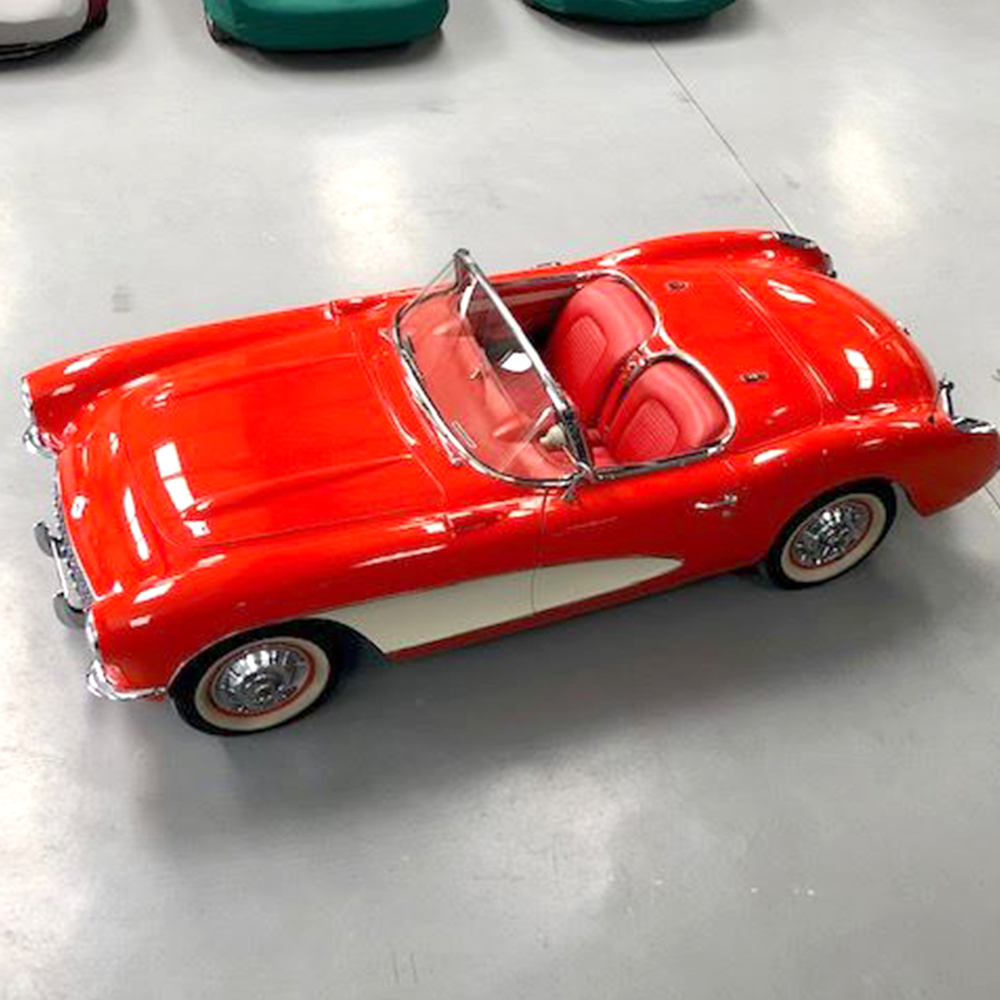 overhead photo of red and cream 1950's corvette c1 housed in topcats racing workshop