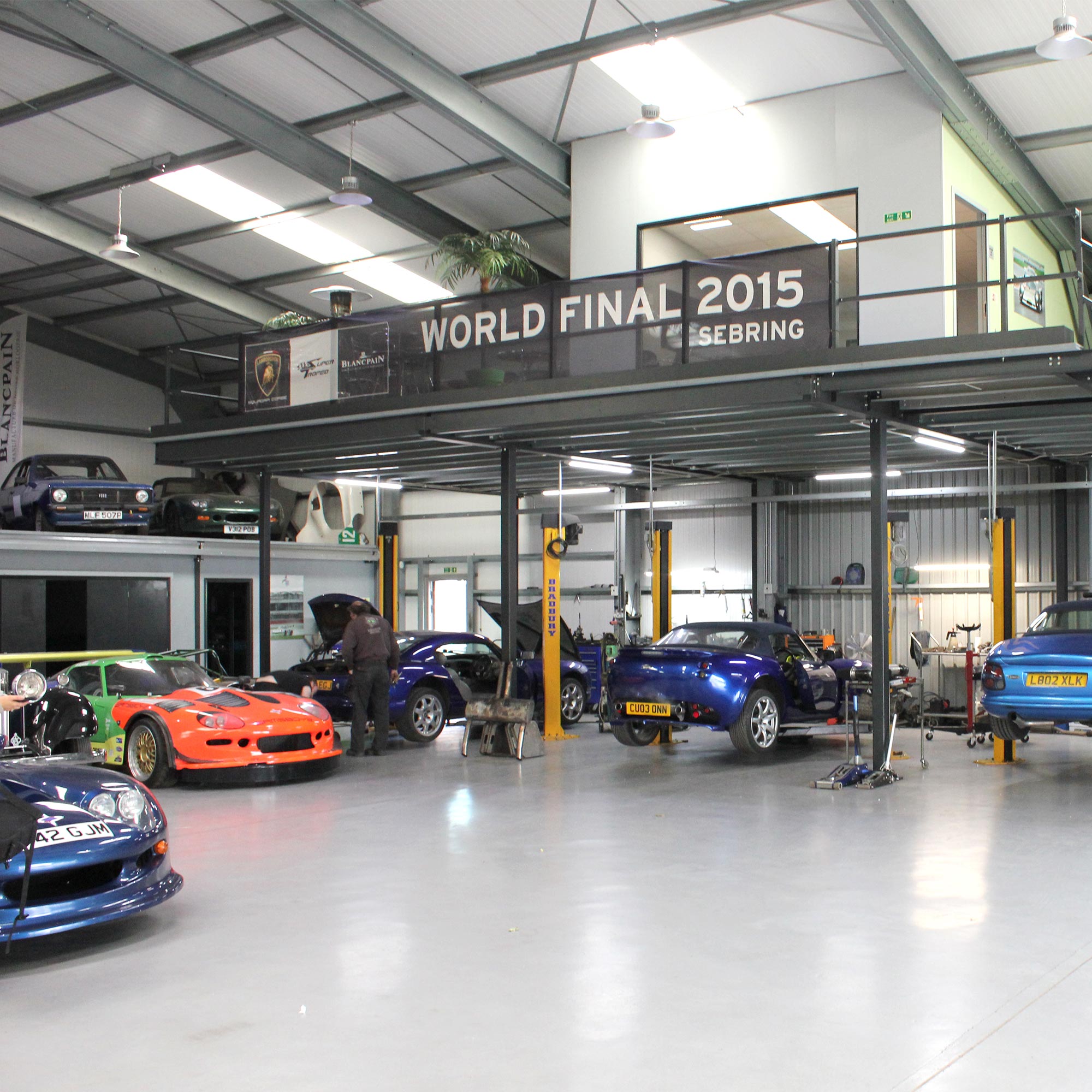 topcats racing workshop with variety of cars on ramp and overlooking balcony in distance