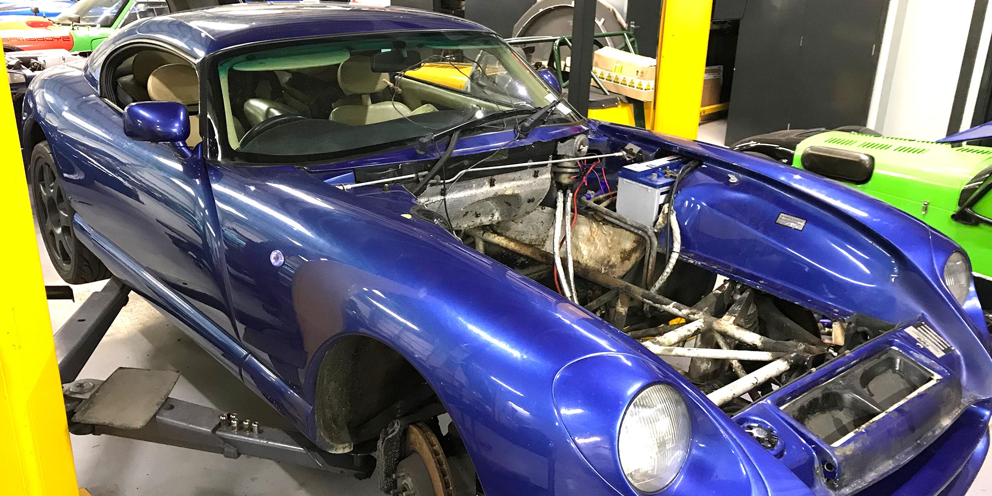 blue tvr cerbera with engine removed on ramp at topcats racing workshop
