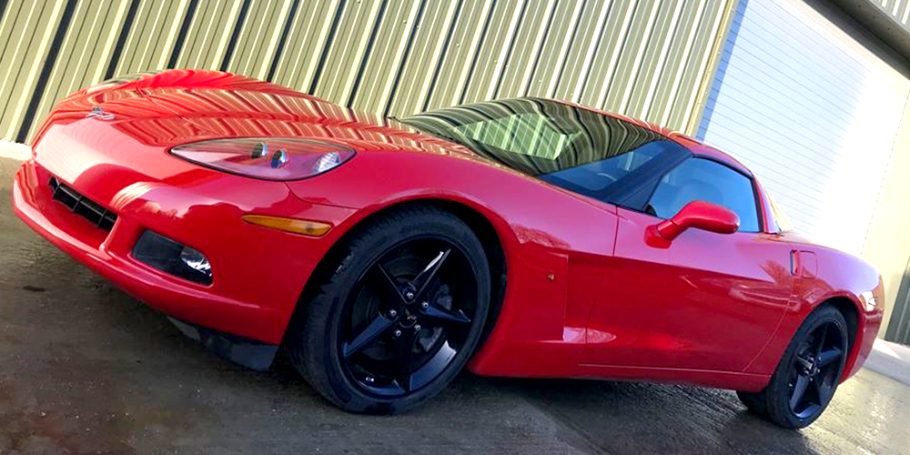 red chevrolette corvette c6 parked outside topcats racing workshop